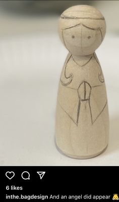 a small wooden figurine sitting on top of a table