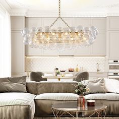 a living room filled with furniture and a chandelier hanging over the top of it