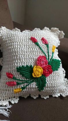 a crocheted pillow with flowers on it