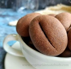 a white bowl filled with chocolate donuts on top of a blue and white table