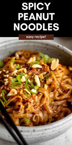 a white bowl filled with noodles and topped with green onions next to chopsticks