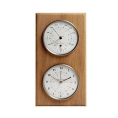 two clocks sitting side by side on top of a wooden board, one with thermometers