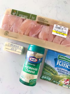 ingredients for chicken and rice laid out on a marble counter top, including raw meat