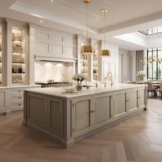 a large kitchen with white cabinets and gold trimmings on the countertops, along with an island