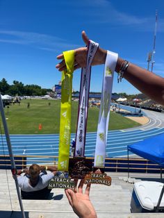 someone holding up their medals in front of the camera at a track and field event