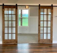 an empty room with sliding glass doors and hardwood floors