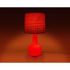 a red lamp sitting on top of a table next to a brown light shade covering