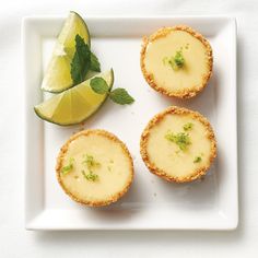 three small pies on a white plate with lime slices