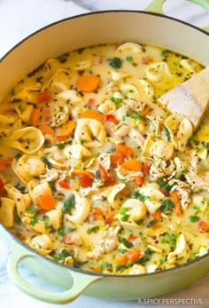 a pot filled with chicken noodle soup on top of a table