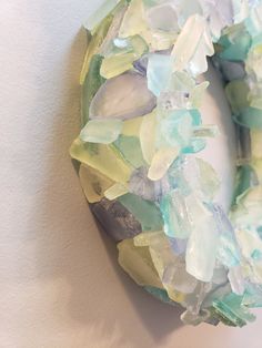 a wreath made out of sea glass sitting on top of a wall