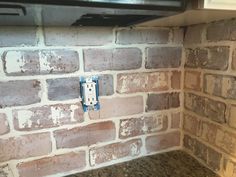 a stove top oven sitting next to a brick wall in a kitchen with granite counter tops