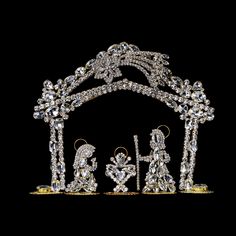 an image of a nativity scene made out of crystal and gold colored stones on a black background