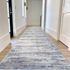 a blue and white rug is on the floor in an empty room with two doors