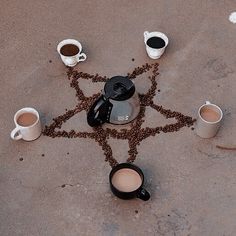 coffee cups are arranged in the shape of a star on top of a concrete floor