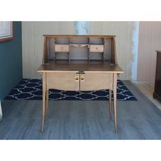 an old desk with two drawers in the middle and a blue rug on the floor