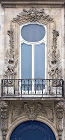 an ornate building with a blue door and balcony