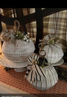 two decorative white pumpkins sitting on top of a table next to each other with bows