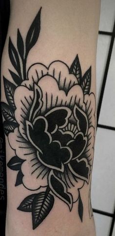 a black and white flower tattoo on the arm