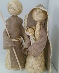 two burlap cloth dolls are standing next to each other, one holding a stick