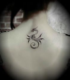 a woman's back neck with a tattoo design on the left side of her neck