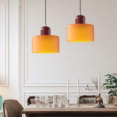 two lamps hanging over a dining room table