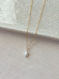 This single freshwater pearl necklace is classic and timeless. The minimal and versatile style looks lovely with both casual and dressy outfits. This is a piece of jewelry that will always be in style! * 14K Gold Filled or 925 Sterling Silver Chain and spring clasp * Choose your length * Natural 9mm Freshwater Pearl (pearl shape: oval to teardrop) * 14/20 gf or 925 stamp for authenticity * Made with all hypoallergenic materials 🤍 See more Pearl Jewelry here!: https://etsy.me/3zMbXyh GET TO KNOW MAGBEE JEWELRY! ✨ 🤍 All MagBee pieces are safe for sensitive skin and made with hypoallergenic Gold Filled or 925 Sterling Silver. 🤍 I only use real/natural gemstones and Pearls. 🤍 Most items are made to order just for you and have a 2-4 day processing time. 💌 All domestic orders over $35 ship Single Pearl Necklace, Single Pearl, Solitaire Necklace, Basic Jewelry, Solitaire Necklaces, Necklace Wedding, Freshwater Pearl Necklace, Necklace Pearl, Keepsake Jewelry