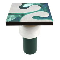 a green and white table with an abstract design on the top, sitting in front of a white background