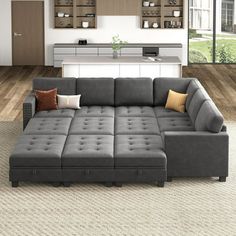 a large gray couch sitting in a living room next to a kitchen