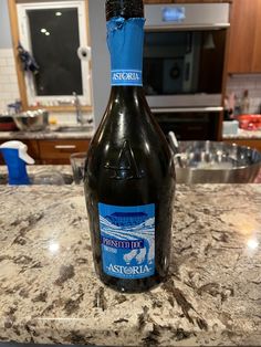 a bottle of wine sitting on top of a kitchen counter