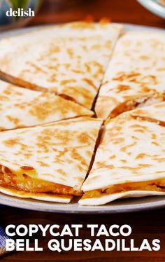 a plate with quesadillas cut into four pieces on top of it and the words copycat taco bell quesadillas written below