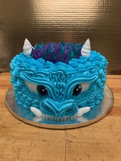 a cake with blue icing and white frosting on top of a wooden table