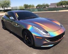 a silver sports car parked in a parking lot with chrome paint on it's hood