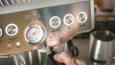 a person is pressing buttons on an espresso machine