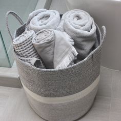 a basket filled with towels on top of a tiled floor