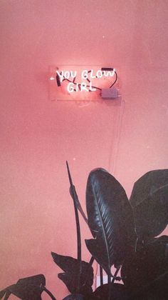 a pink wall with a neon sign that says you glow girl