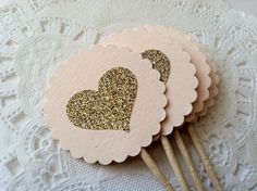 small pink and gold heart shaped paper picks on a lace tablecloth with doily