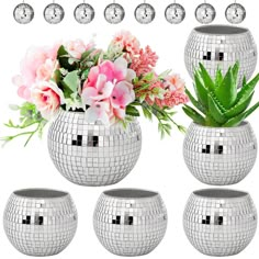 a set of four silver disco ball vases with flowers and succulents