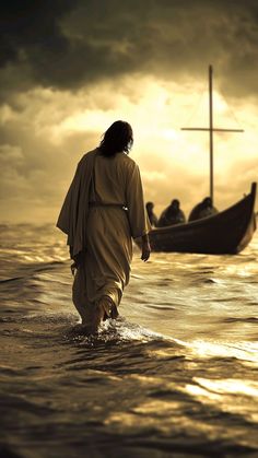 a man walking in the water towards a boat with a cross on it's side