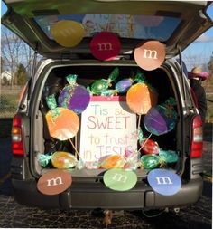 the back end of a van decorated with candy and balloons for a sweet to trust in jesus