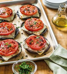 a pan filled with sliced tomatoes on top of a wooden table