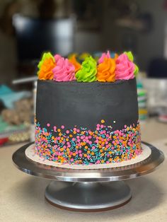 a colorful cake with sprinkles and flowers on it