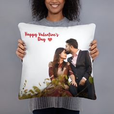 a woman holding a pillow with an image of a man kissing a woman on the cheek