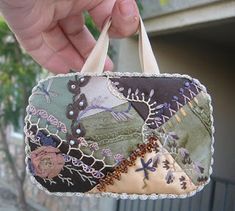 a hand holding a small patchwork purse