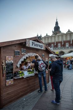 people are standing in front of a food stand