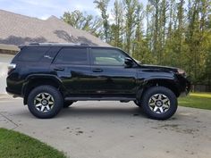 a black suv parked in front of a house