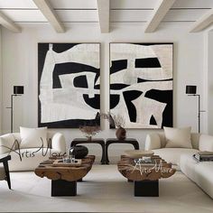 a living room filled with white furniture and paintings