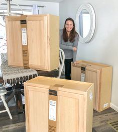 a woman standing next to some boxes in a room