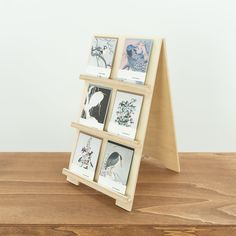 a wooden stand with four pictures on it and one has a bird in the middle