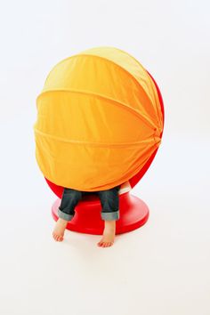 a small child sitting on top of a red object