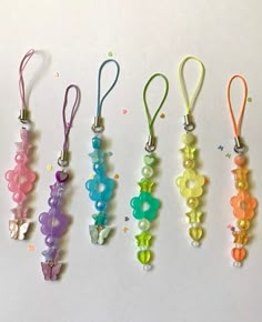 five different colored beads are hanging from lanyards